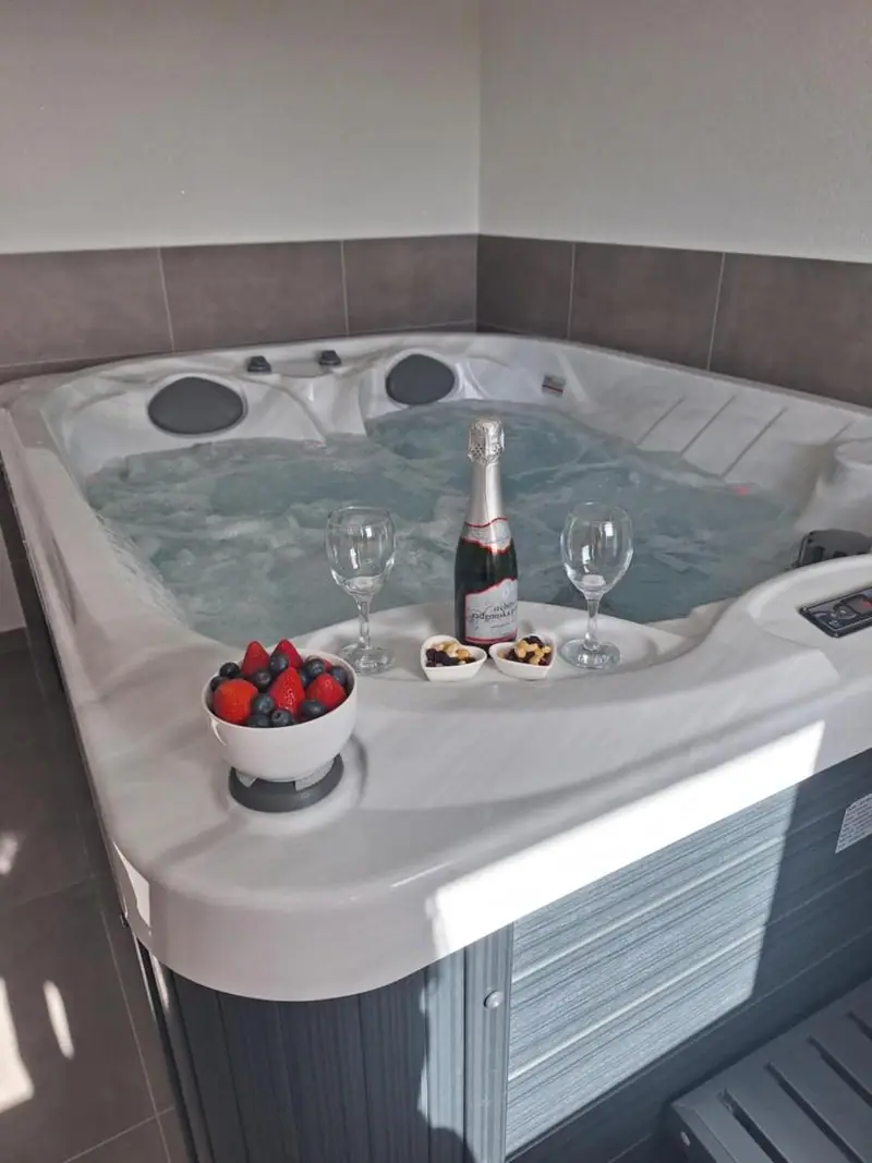 Unutarnji jacuzzi pripremljen s pjenušcem, dvije čaše i jagodama